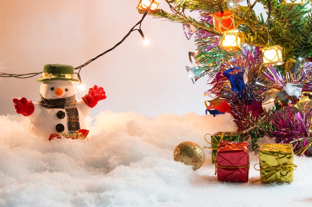 Snowman stand in pile of snow.