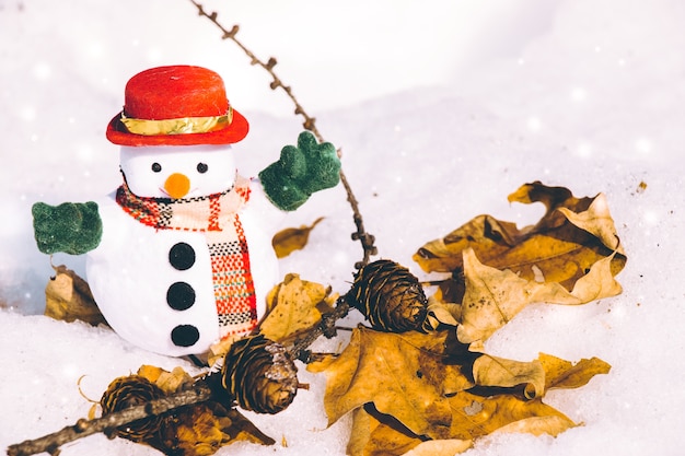 Snowman stand in pile of snow. 