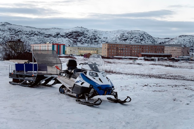 A snowmobile with a trailer for transporting tourists in the village of Teriberka, Russia, Kola poluostrov.