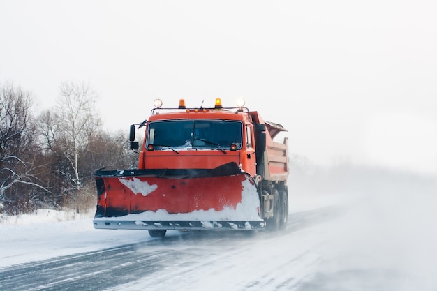 Photo snowplow working in winter snow storm