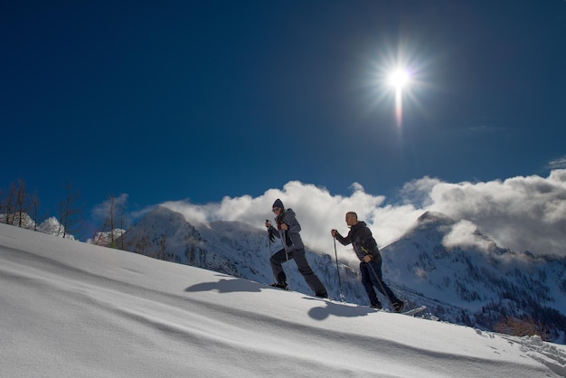 Snowshoes practiced by a boy and a girl in the warm mountain sun