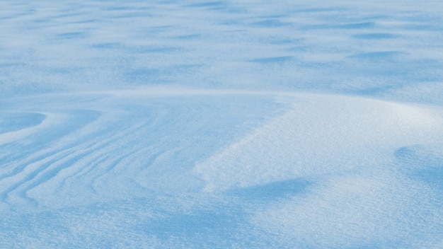 Sfondo innevato, superficie innevata della terra dopo una bufera di neve al mattino alla luce del sole con distinti strati di neve