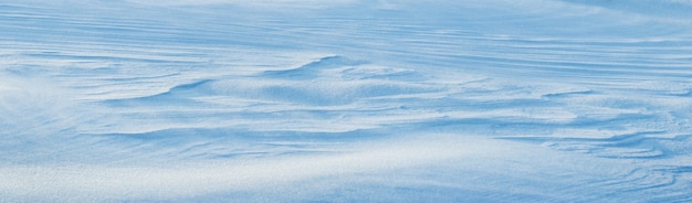 写真 雪に覆われた背景、明確な雪の層を伴う日光の下での朝の吹雪の後の雪に覆われた地球の表面