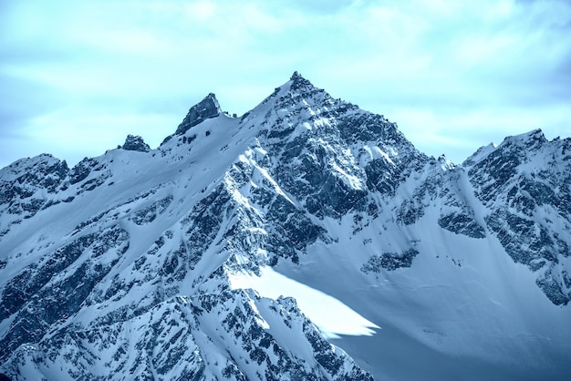 雲の中の雪に覆われた青い山。冬のスキーリゾート