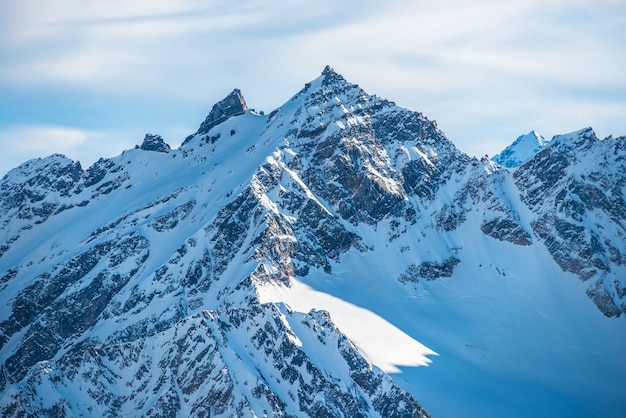 Snowy blue mountains in clouds.