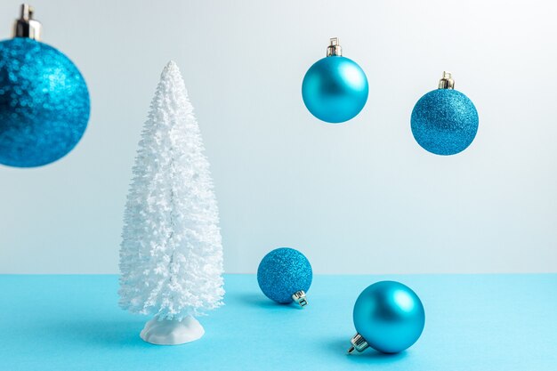 Snowy Christmas tree with Christmas decoration on blue table