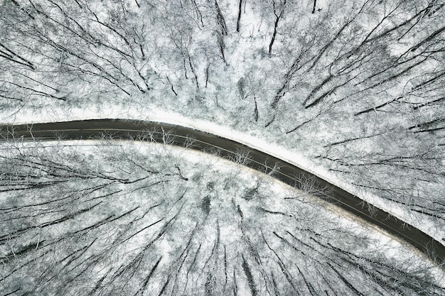 道路のある雪に覆われた森。空中写真。