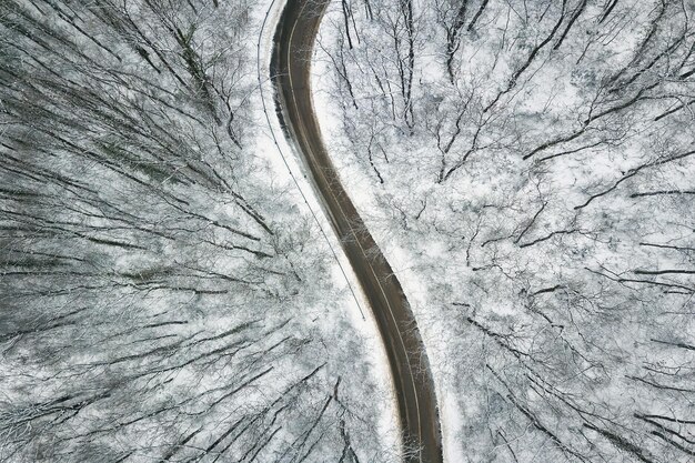 道路のある雪に覆われた森。空中写真。