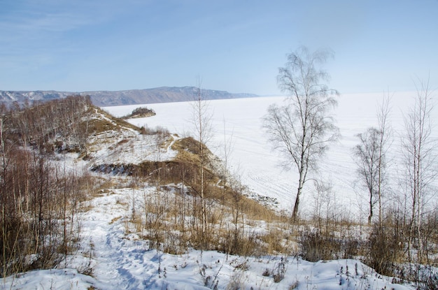 A snowy landscape with trees and a lake in the background Sludyanka Irkutsk region