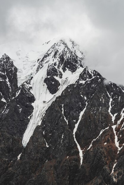 Snowy mountain peak covered by mist