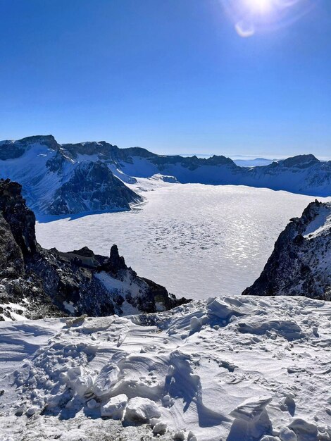 Photo a snowy mountain with a lake in the middle