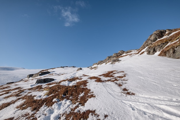 Фото Снежная гора со скалами и голубым небом в альпийских горах зимой