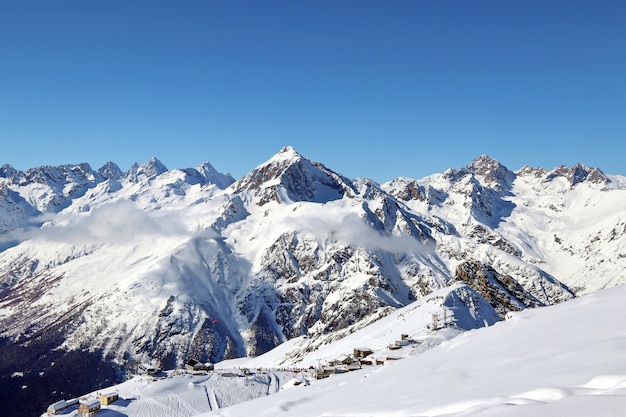 Picchi delle montagne innevate nel cielo blu delle nuvole caucaso