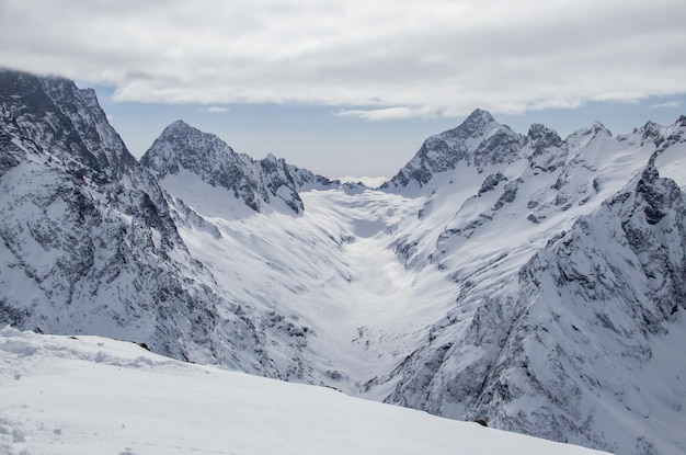 Snowy mountains peaks in the clouds blue sky caucasus