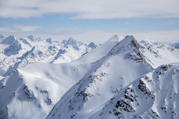 Snowy mountains peaks in the clouds blue sky caucasus