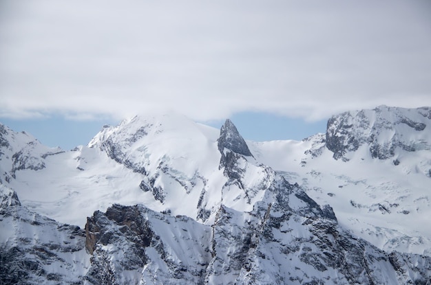 Snowy mountains peaks in the clouds blue sky caucasus