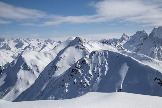 Snowy mountains peaks in the clouds blue sky caucasus