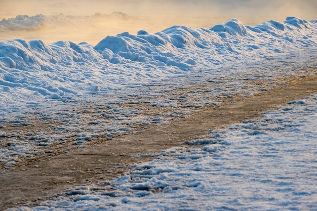 Snowy path by the river in a cold winter day. Nobody