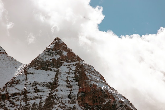 Snowy rocky mountain on cloudy day