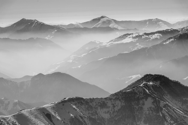 Snowy winter mountains in sun day. Caucasus Mountains, Georgia, from ski resort Gudauri