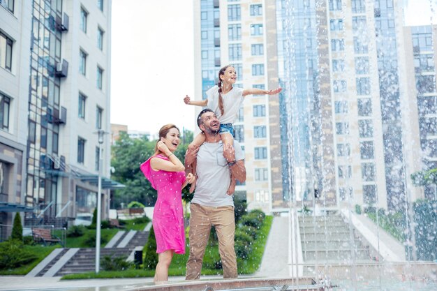 So beautiful. Delighted happy family standing together while looking at the beautiful fountain