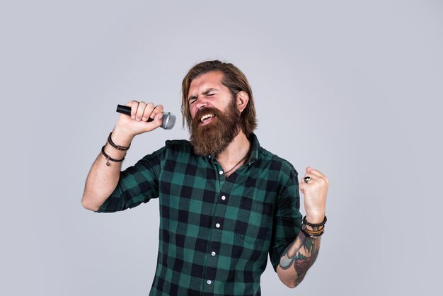 So emotional bearded man concept of music he is rock star brutal stylish singer singing in karaoke mature hipster with beard sing song brutal caucasian guy with microphone