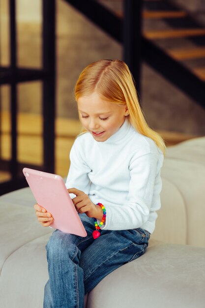 So pleased. Attentive child expressing positivity while spending free time in living room