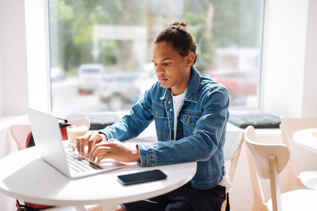 Così serio. uomo concentrato che trascorre del tempo al bar e scrive messaggi sul suo laptop