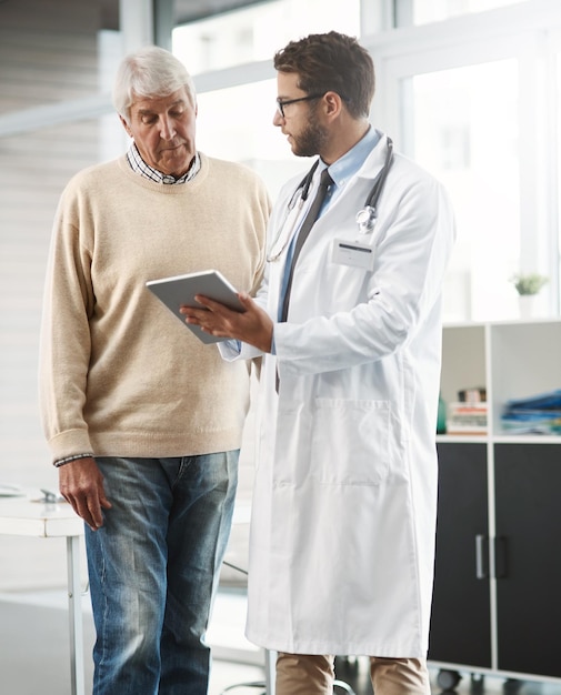 So this link will bring up all your medical history Cropped shot of a young male doctor showing his senior male patient something on a digital tablet