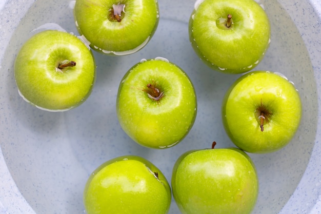 Soak green apples in water. washing fruit concept