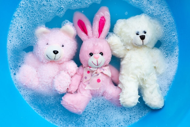 Soak rabbit doll with  toy bears in laundry detergent water 