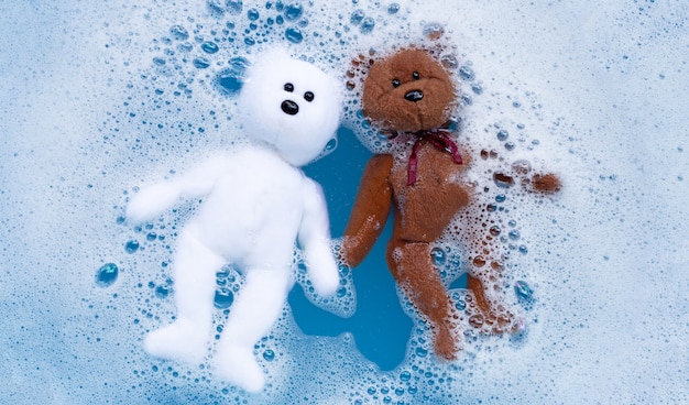 Soak toy teddy bear in laundry detergent water dissolution before washing.