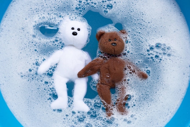 Soak toy teddy bear in laundry detergent water dissolution before washing.