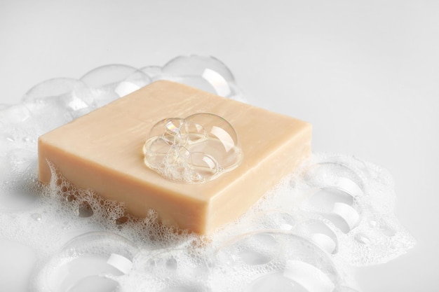 Soap bar and foam on white background