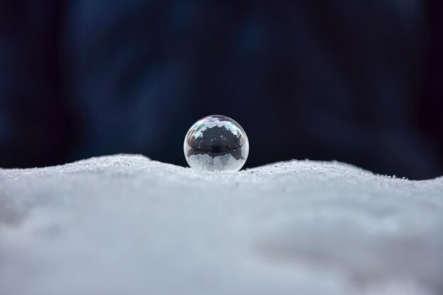 Soap bubble frozen in winter in the frost. transparent ball\
made of liquid.