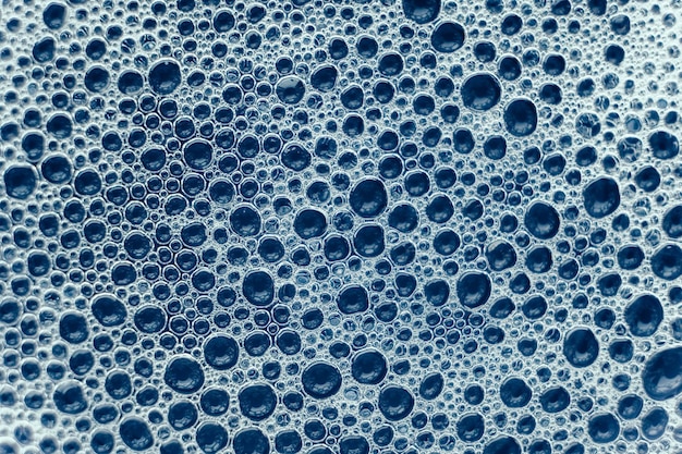 Soap bubbles on a background of blue water as a texture Top view Copy empty space for text