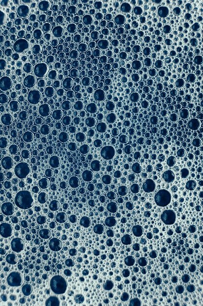 Soap bubbles on a background of blue water as a texture Top view Copy empty space for text