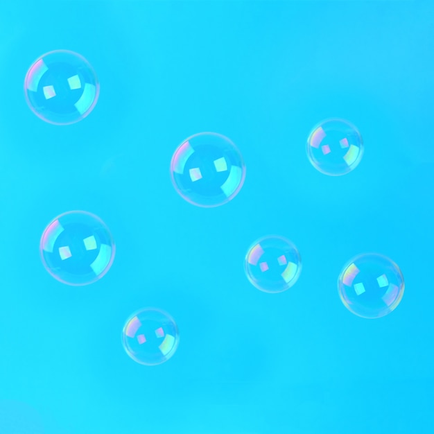 Soap bubbles on a blue pastel background. Minimalism.