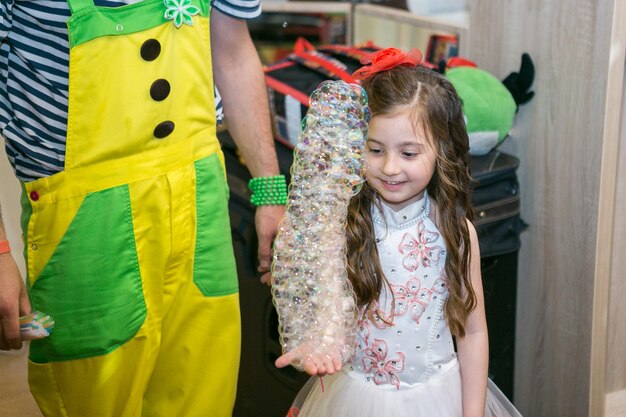 シャボン玉は子供たちのパーティーでピエロを示していますピエロは子供たちのイベントのためのショーを開催します