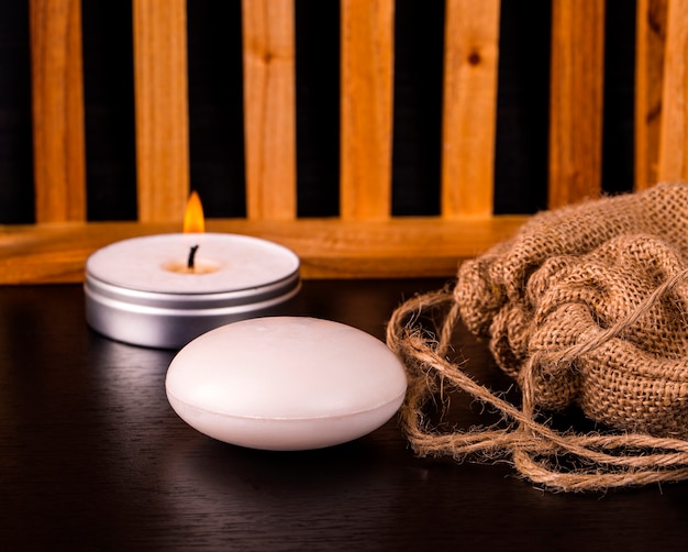 Soap, candle and burlap on table