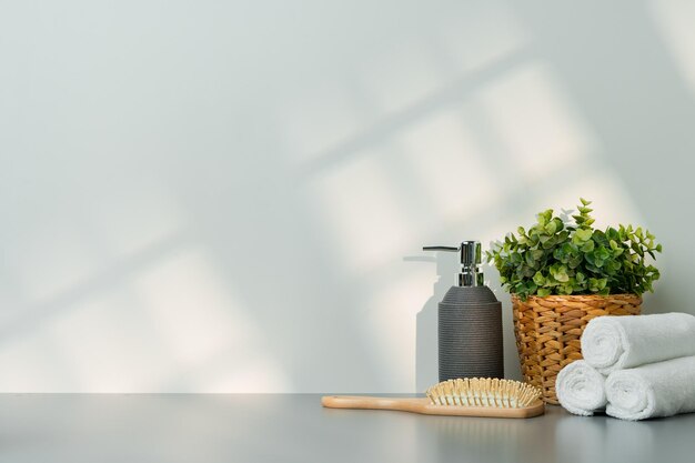 Soap dispenser and spa towels on white background in shadow