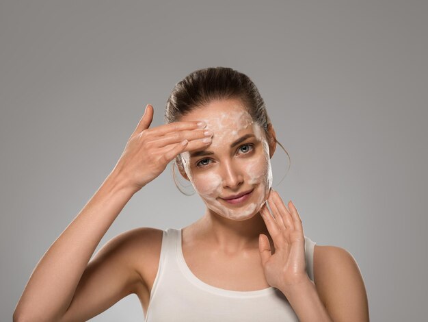 Soap face woman clean skin beauty. Color background. Gray