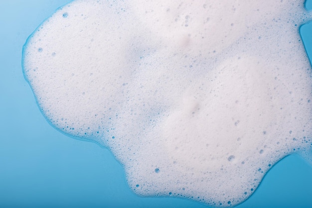 Foto schiuma di sapone su sfondo blu il concetto di pulizia igienica