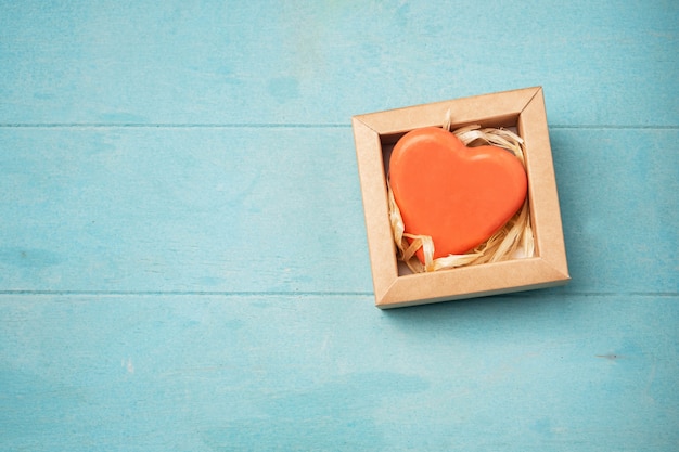 Soap in the form of a heart in a gift box on a blue surface,