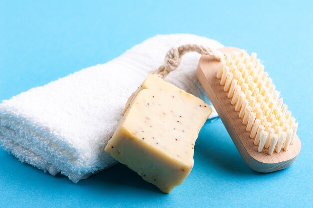 Foto sapone, asciugamano bianco e spazzola di legno