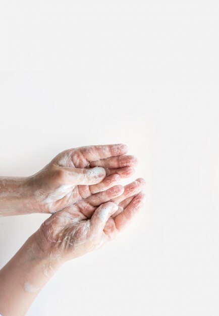 Soapy hands on a light background.