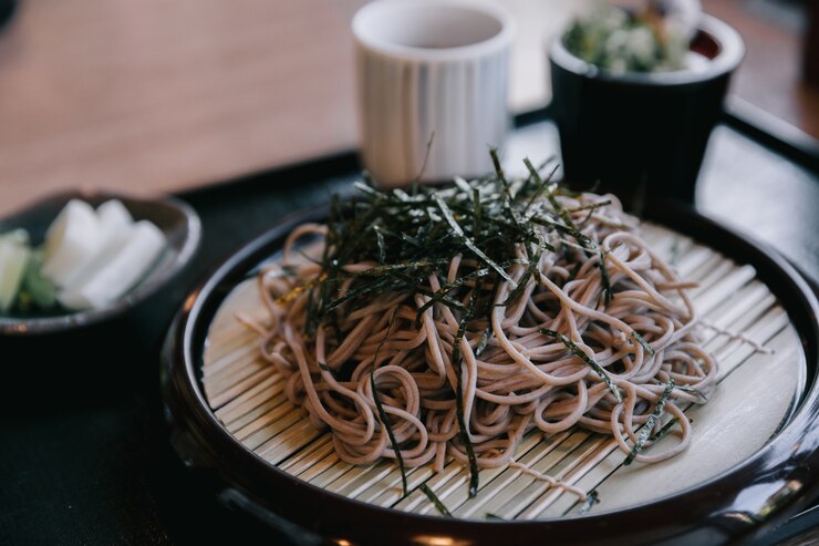 Photo 木の背景にスープとそばの麺