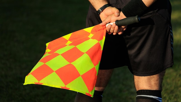 Photo soccer assistant referee on the field holding the flag