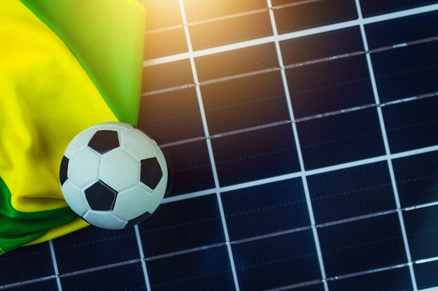 Футбольный мяч и флаг Бразилии над фотогальваническими солнечными панелями Кубок мира и технологическая концепция изображения для дизайна