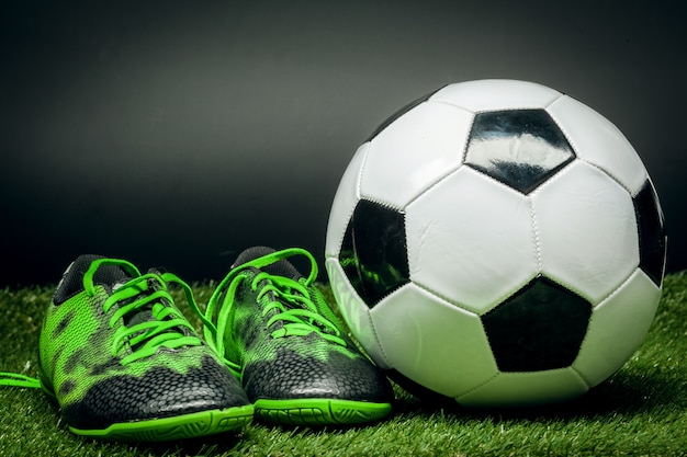 Soccer ball and cleats on the football field